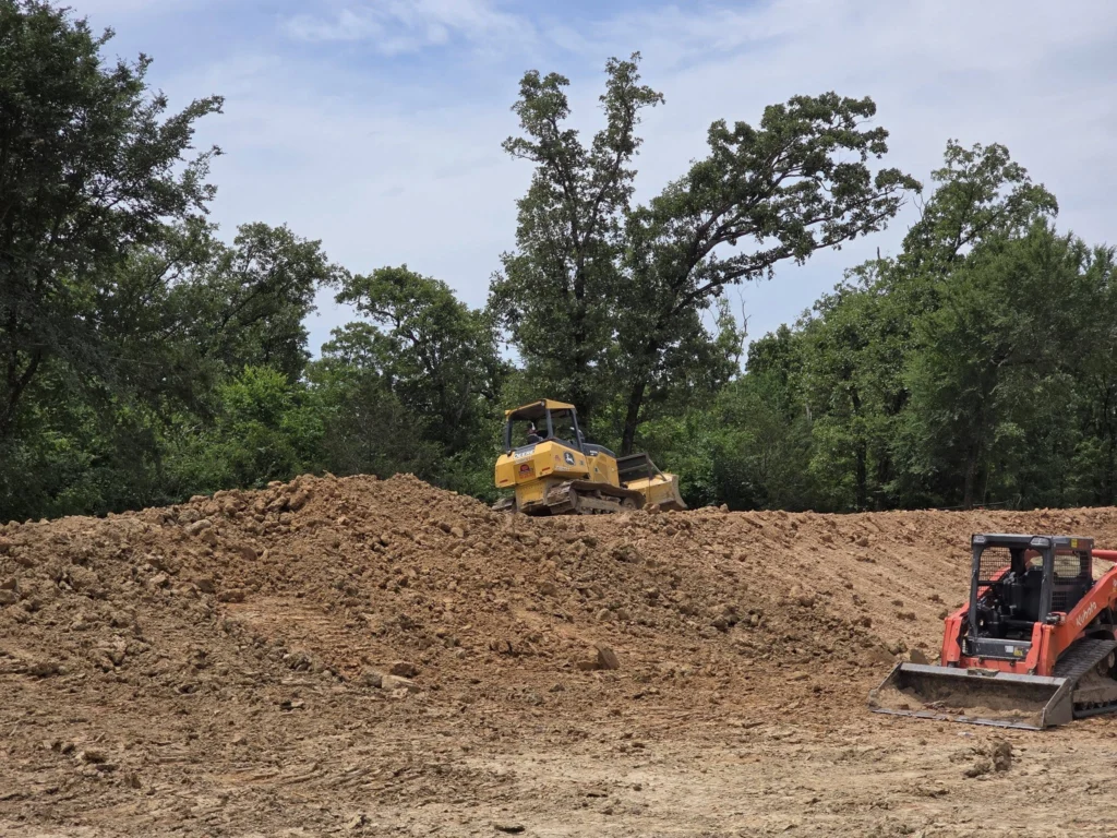 Dozer working a dirt pile with a track loader beside it on a site in East Texas